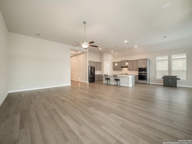 unfurnished living room with hardwood / wood-style floors and ceiling fan