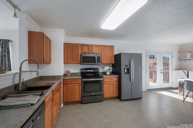 kitchen with sink, french doors, a textured ceiling, appliances with stainless steel finishes, and ornamental molding