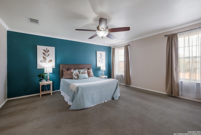 carpeted bedroom with a textured ceiling, multiple windows, ornamental molding, and ceiling fan