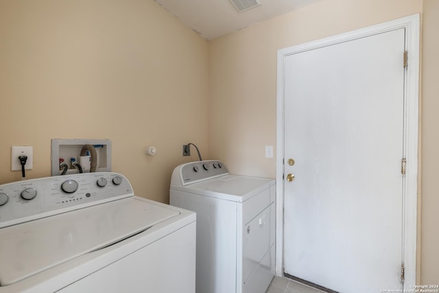 laundry area with light tile patterned floors and independent washer and dryer