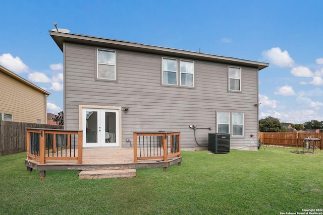 rear view of property featuring a lawn, central AC, french doors, and a deck