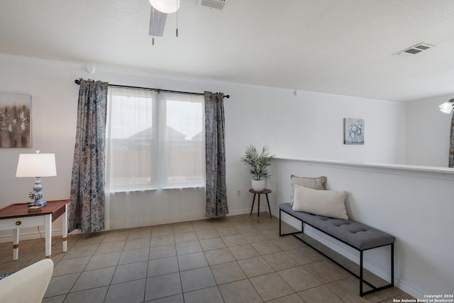 living area featuring light tile patterned floors and ceiling fan