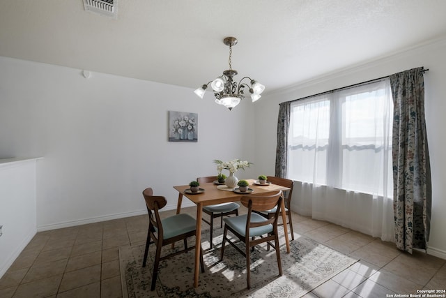 dining area with a chandelier and tile patterned floors