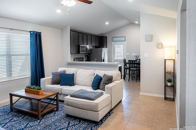 tiled living room with ceiling fan and vaulted ceiling