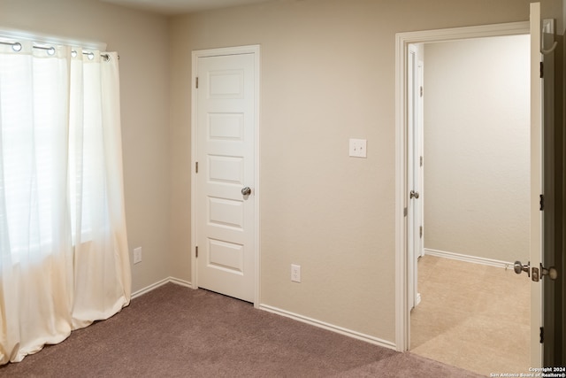 unfurnished bedroom with light colored carpet