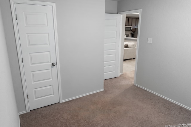 hall with light colored carpet