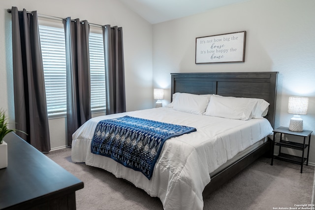 bedroom featuring light colored carpet and lofted ceiling