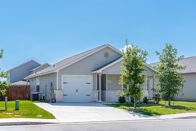 view of front of property with a front lawn, central AC unit, and a garage