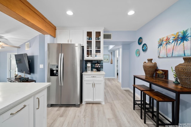 kitchen featuring white cabinetry, ceiling fan, stainless steel fridge with ice dispenser, light hardwood / wood-style flooring, and backsplash