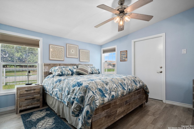 bedroom with hardwood / wood-style flooring, ceiling fan, and vaulted ceiling