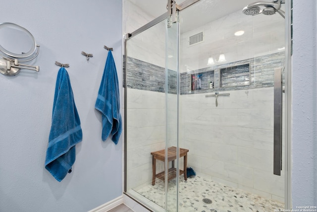 bathroom featuring a shower with door