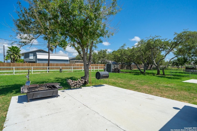 view of patio featuring a shed and an outdoor fire pit