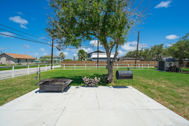 view of patio featuring an outdoor fire pit and a storage shed