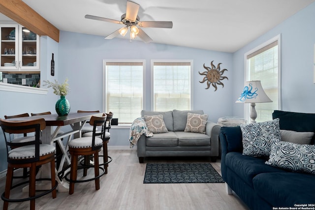 living room with ceiling fan, a healthy amount of sunlight, vaulted ceiling, and light wood-type flooring