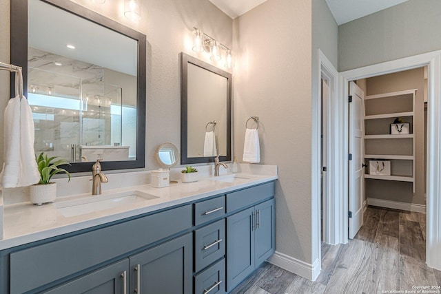 bathroom with hardwood / wood-style flooring, vanity, and an enclosed shower