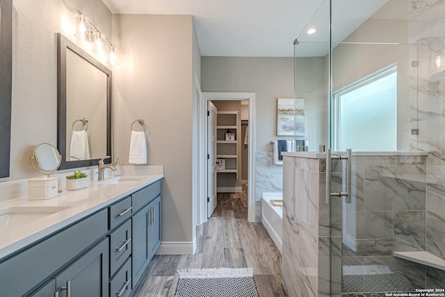 bathroom featuring hardwood / wood-style flooring, vanity, and plus walk in shower