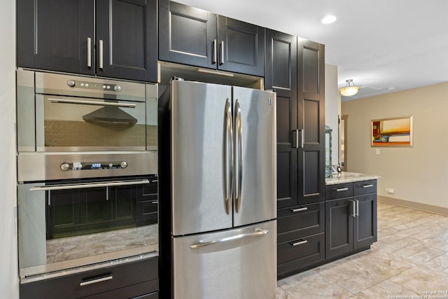 kitchen with light stone countertops and appliances with stainless steel finishes