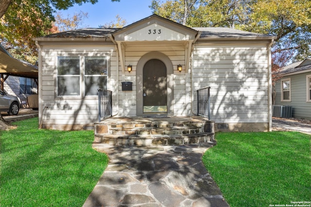 view of front of home featuring a front yard and central air condition unit