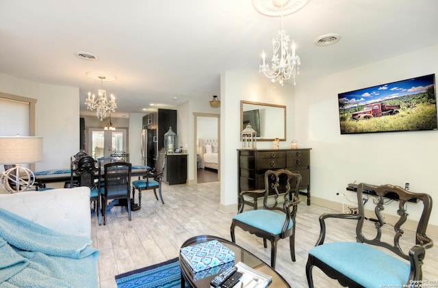 living room featuring french doors, an inviting chandelier, and light hardwood / wood-style flooring