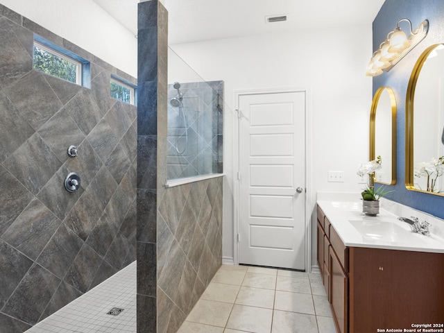 bathroom featuring tile patterned floors, vanity, and a tile shower