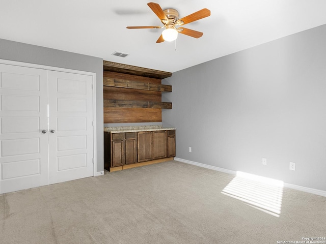 interior space with ceiling fan and light carpet