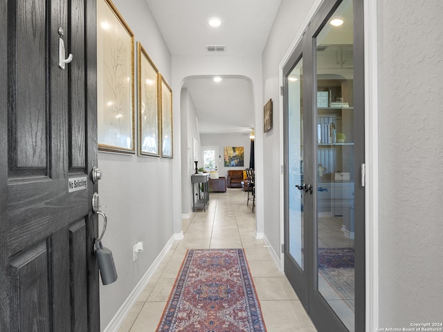 hallway featuring light tile patterned floors and french doors