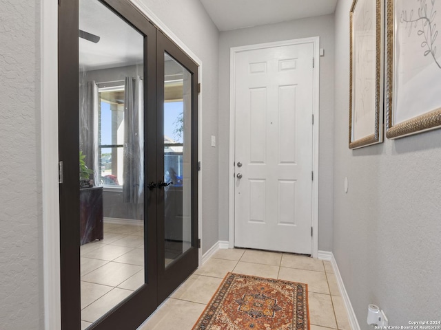 doorway to outside featuring light tile patterned flooring and french doors