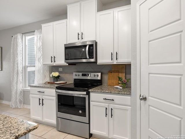 kitchen with white cabinets, backsplash, and appliances with stainless steel finishes