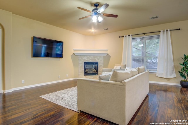 living room featuring a fireplace, dark hardwood / wood-style flooring, and ceiling fan