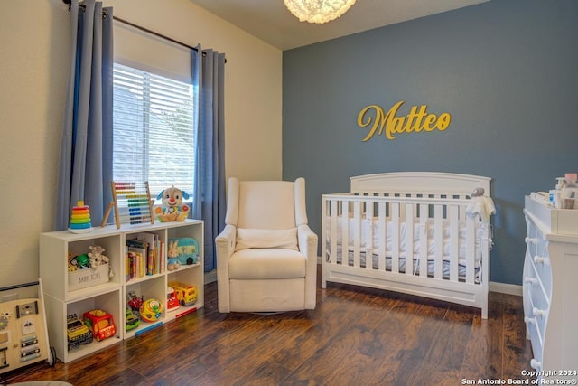 bedroom with dark wood-type flooring and a nursery area