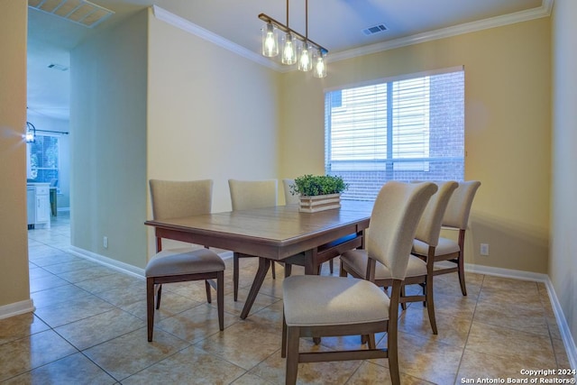 tiled dining room featuring ornamental molding