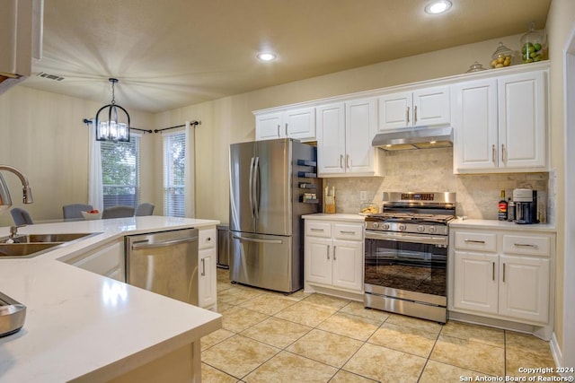 kitchen with pendant lighting, sink, appliances with stainless steel finishes, a notable chandelier, and white cabinetry