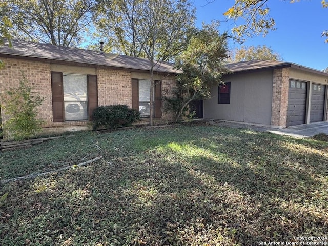 single story home with a garage and a front lawn