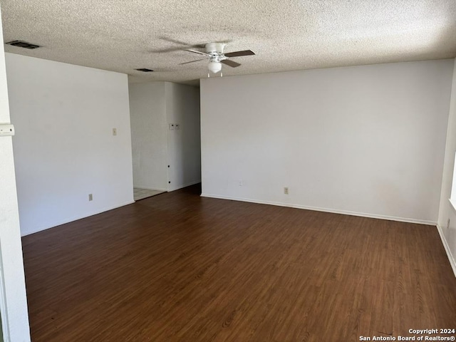 spare room featuring a textured ceiling, ceiling fan, and dark wood-type flooring