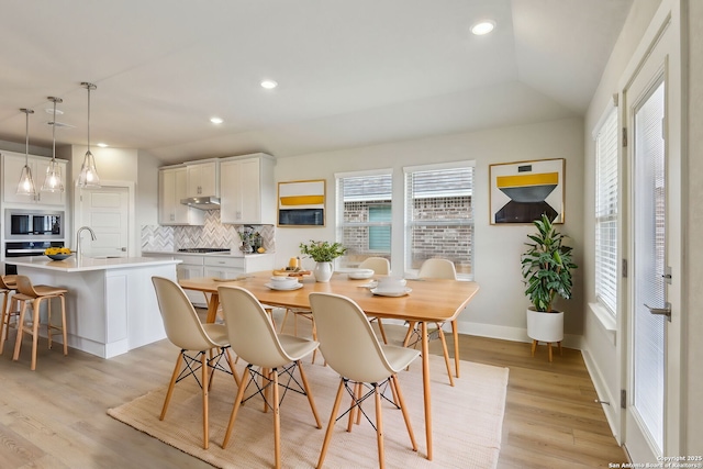 dining space with sink and light wood-type flooring