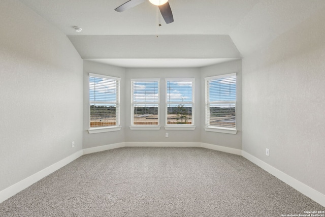 carpeted empty room featuring vaulted ceiling and ceiling fan