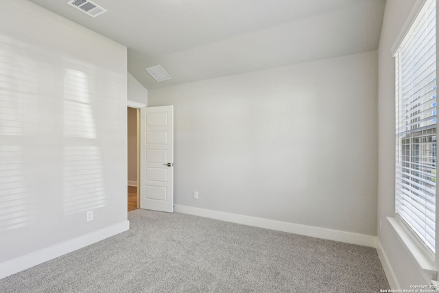 carpeted empty room with vaulted ceiling and a healthy amount of sunlight