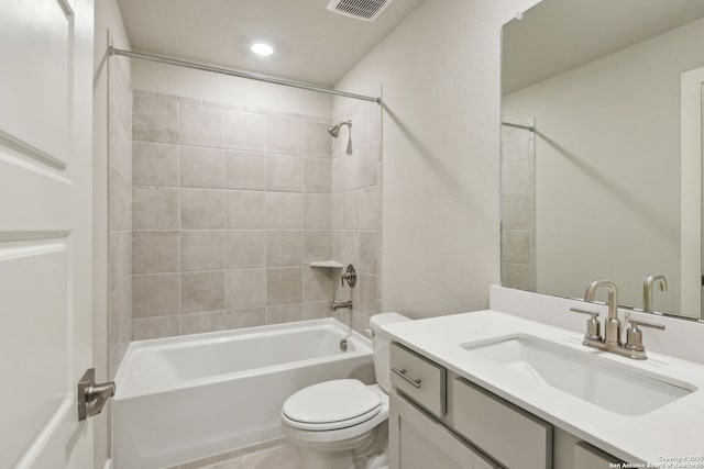 full bathroom with tiled shower / bath, vanity, and toilet