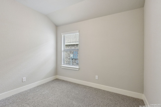 carpeted empty room with lofted ceiling