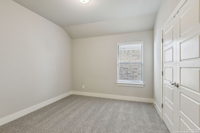 unfurnished bedroom with light colored carpet and vaulted ceiling