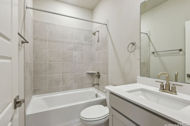 full bathroom featuring vanity, tiled shower / bath combo, and toilet