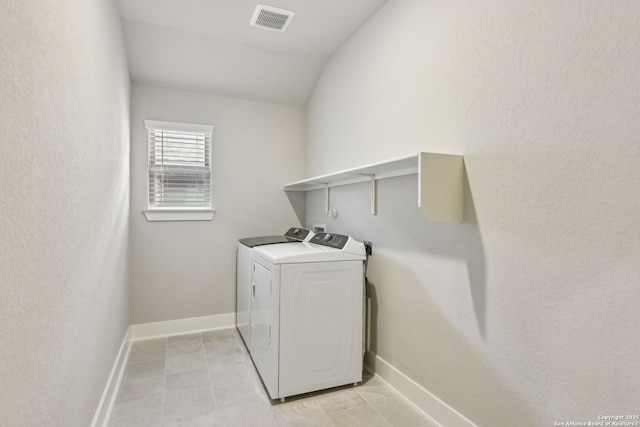 laundry room featuring washing machine and clothes dryer and light tile patterned floors