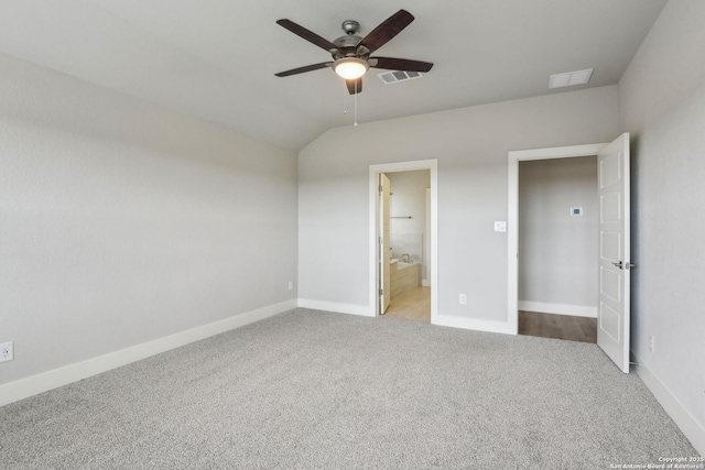 unfurnished bedroom with connected bathroom, vaulted ceiling, light colored carpet, and ceiling fan