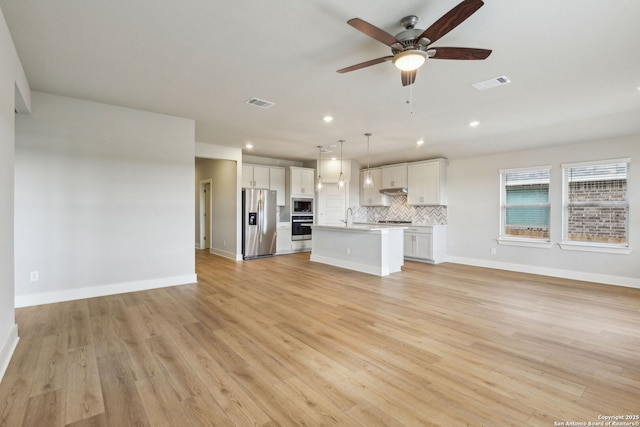 unfurnished living room with sink, light hardwood / wood-style flooring, and ceiling fan