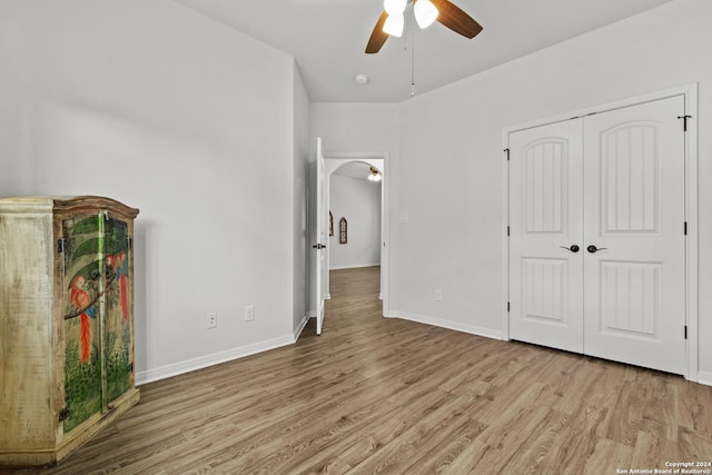 unfurnished bedroom featuring ceiling fan, a closet, and light hardwood / wood-style flooring