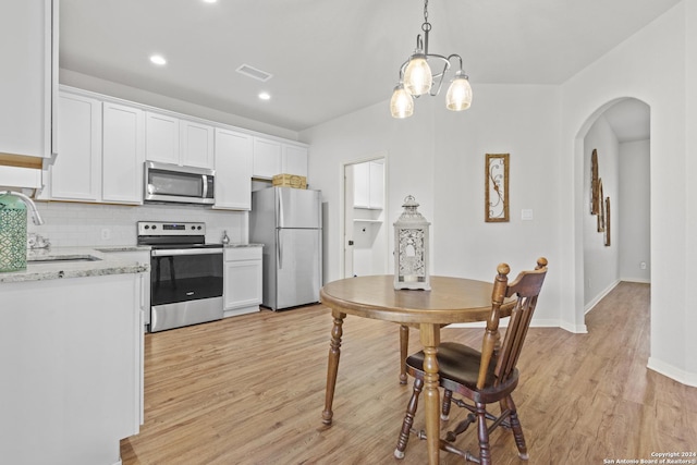 kitchen with sink, white cabinets, light hardwood / wood-style floors, and appliances with stainless steel finishes