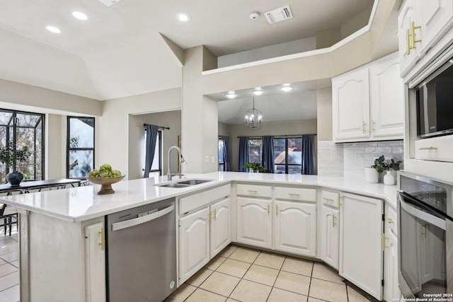 kitchen with kitchen peninsula, white cabinetry, sink, and appliances with stainless steel finishes