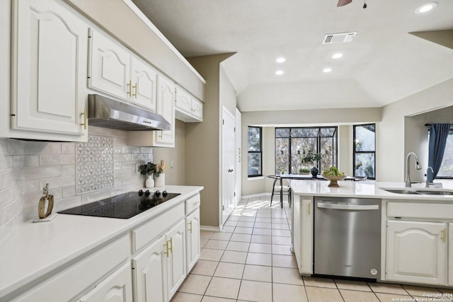 kitchen featuring lofted ceiling, black electric stovetop, sink, stainless steel dishwasher, and white cabinetry