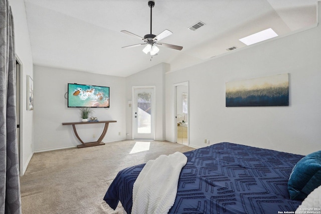 carpeted bedroom featuring ensuite bath, lofted ceiling with skylight, and ceiling fan