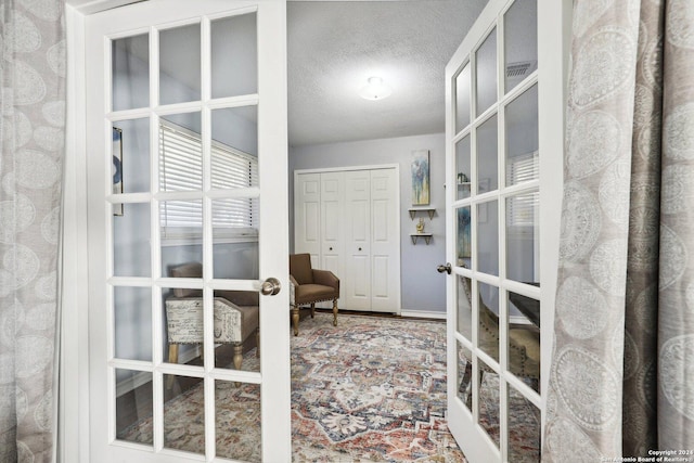 interior space featuring french doors and a textured ceiling